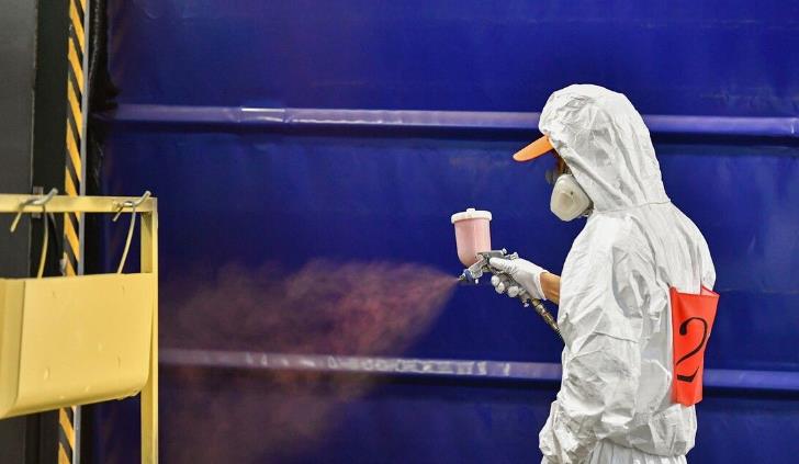 a worker is painting in paint booth