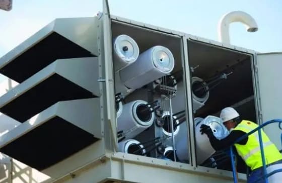 An engineer is installing cartridge filter in gas turbine air intake system